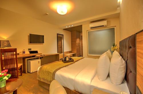 a hotel room with a bed and a desk at Hotel 91 Huda City Centre in Gurgaon