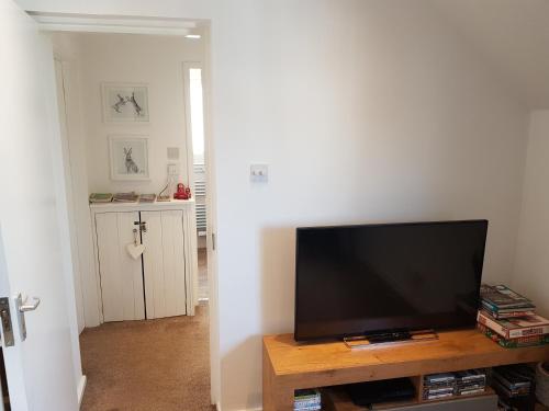 a living room with a flat screen tv on a table at Bowness On Windermere, Lovely Apartment for 4 With Parking in Bowness-on-Windermere