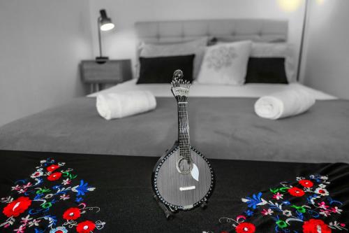 une guitare est assise au-dessus d'un lit dans l'établissement Aveiro, Ria e Fado, à Aveiro