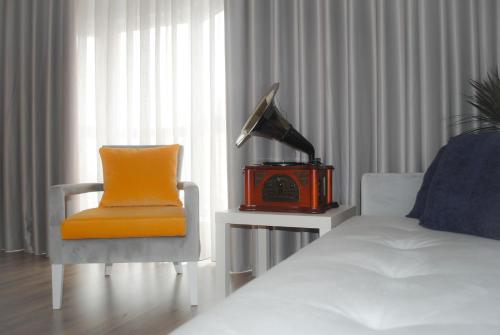 um quarto com uma cama, uma cadeira e um candeeiro em Aveiro, Ria e Fado em Aveiro