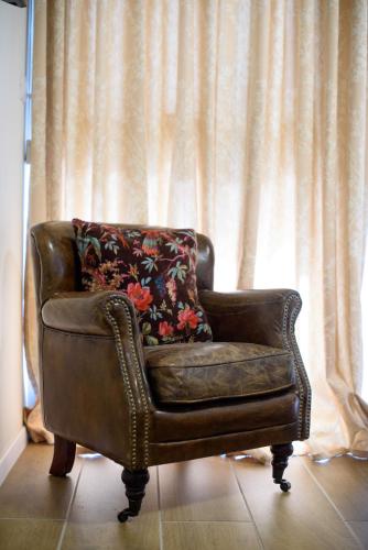 a brown leather chair sitting in front of a curtain at Dream Penthouse in Haifa