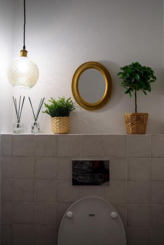 a bathroom with two potted plants and a mirror at Dream Penthouse in Haifa