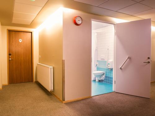 a bathroom with a toilet and a clock on the wall at Loft - HI Eco Hostel in Reykjavík