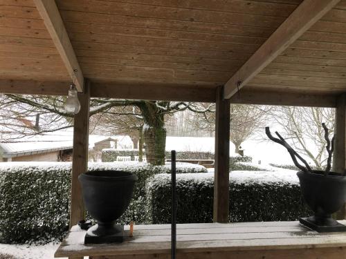 a gazebo with two vases on it in the snow at B&B de Tol in Hulst
