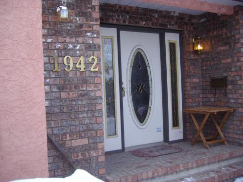 a brick wall with a door with a clock on it at Beds By the Bridge in Kelowna