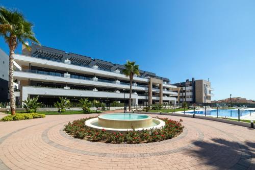 a large building with a fountain in the middle of a courtyard at Flamenca Village by Mar Holidays in Orihuela