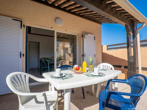 a white table and chairs on a patio at Holiday Home Hacienda Beach II-4 by Interhome in Cap d'Agde