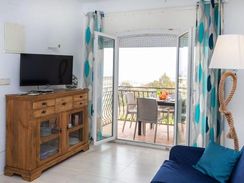 a living room with a tv and a balcony at Apartment Santa Isabel by Interhome in Llança