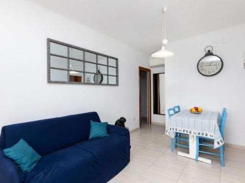 een woonkamer met een blauwe bank en een tafel bij Apartment Santa Isabel by Interhome in Llança