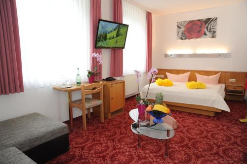una camera d'albergo con letto e tavolo di Hotel Goldner Anker a Bad Elster
