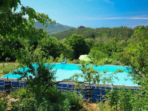 una grande piscina blu in mezzo a una foresta di Holiday Home La Vecchia Fattoria by Interhome a Santa Fiora