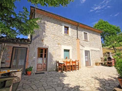 una vista esterna di una casa in pietra con tavolo e sedie di Holiday Home La Vecchia Fattoria by Interhome a Santa Fiora