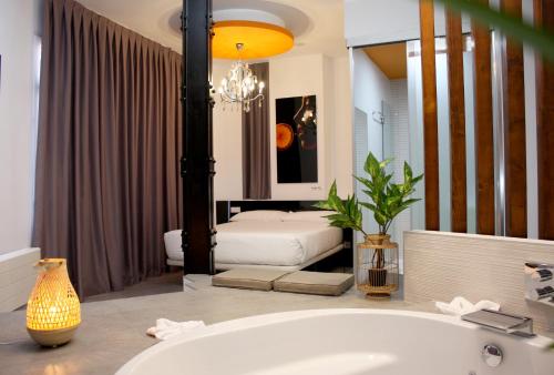 1 dormitorio con 2 camas y baño con bañera. en Vitium Urban Suites, en Madrid