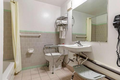 uma casa de banho com um lavatório, um WC e um espelho. em Econo Lodge em Tallahassee
