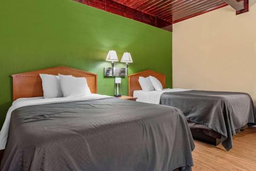 two beds in a room with green walls at Econo Lodge Tallahassee Near Capital -University in Tallahassee