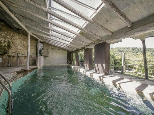 ein Wasserbecken mit Stühlen in einem Gebäude in der Unterkunft Holiday Home Antico Borgo del Riondino by Interhome in Trezzo Tinella