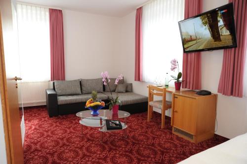 a living room with a couch and a table at Hotel Goldner Anker in Bad Elster