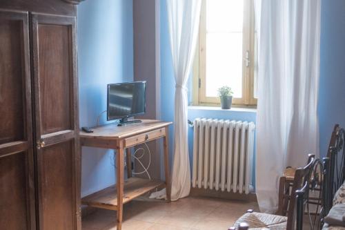 Habitación con escritorio, TV y ventana. en Masseria Sant'Agapito, en Lucera