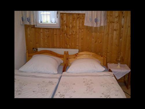 a bedroom with a bed with two pillows and a window at Ferienhaus Jupp-Schöttler-Jugendherberge in Finnentrop