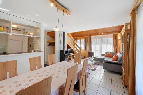 a kitchen and living room with a table and a couch at Apartments Kirchbühl in Grindelwald