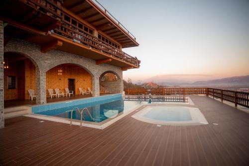 a house with a swimming pool on a deck at Wooden House in Shkodër