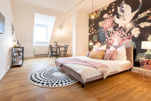 a bedroom with a bed and a large painting on the wall at Design Apartment Zentral & Rooms - Toplage am Opernhaus in Nürnberg