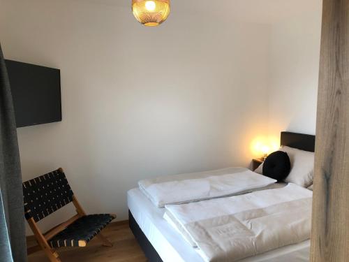 a bedroom with a bed and a chair and a tv at Ski & Nature Apartment in Mauterndorf