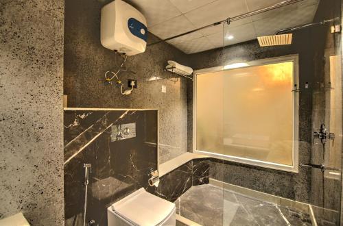 a bathroom with a shower and a toilet and a window at Hotel 91 Huda City Centre in Gurgaon