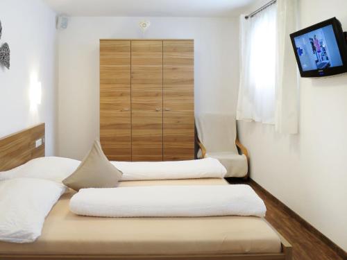 two beds in a room with a tv on the wall at Apartment Marina - MHO622 by Interhome in Schwendau