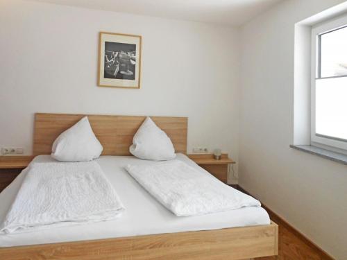 een slaapkamer met een bed met witte lakens en een raam bij Apartment Hanser - MHO752 by Interhome in Ramsau im Zillertal