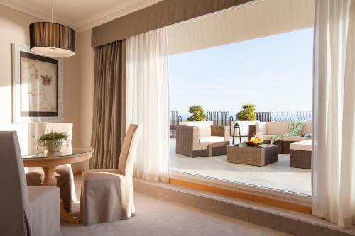 a living room with a table and chairs and a large window at Hotel Croatia in Cavtat