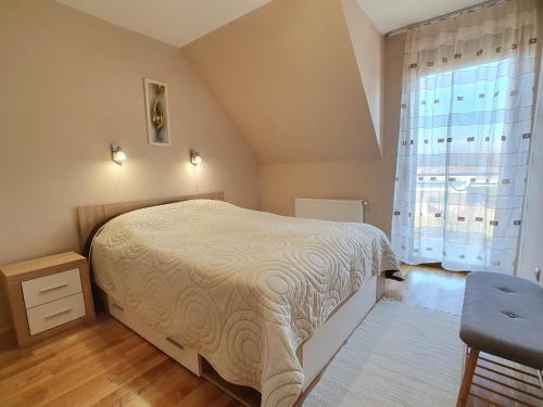 una camera da letto con un letto grande e una finestra di Dorci apartman - Nr 178 Biró Tours a Keszthely