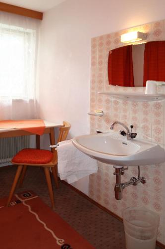 a bathroom with a sink and a mirror and a stool at Holiday Home Palman by Interhome in Pfunds