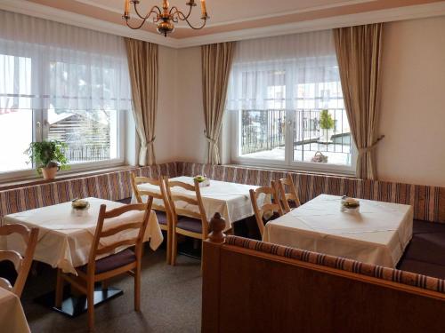 カップルにあるHoliday Home Apart Garni Niederhof - KPL119 by Interhomeのテーブル2台と窓2つ付きのレストラン