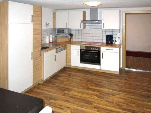 una cucina con armadietti bianchi e pavimenti in legno di Holiday Home Mario - KPL340 by Interhome a Kappl