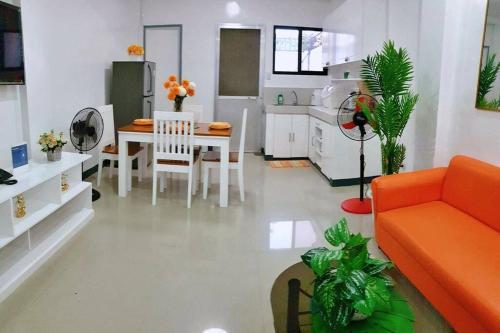 - un salon avec un canapé orange et une table dans l'établissement Diodeths Holiday Apartment, à Butuan