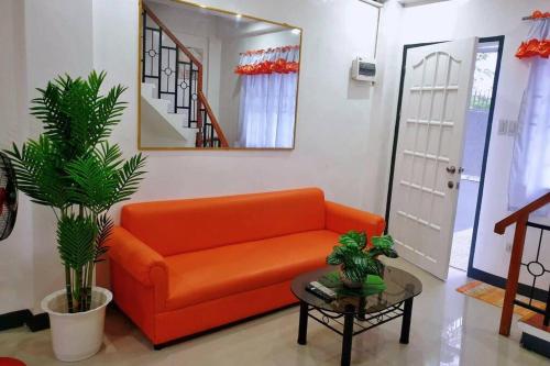 - un canapé orange dans le salon avec un miroir dans l'établissement Diodeths Holiday Apartment, à Butuan