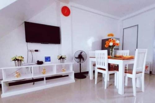 - une salle à manger blanche avec une table et des chaises blanches dans l'établissement Diodeths Holiday Apartment, à Butuan