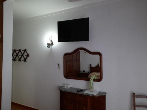 baño con espejo y TV en la pared en Residencial das Trinas 2, en Guimarães