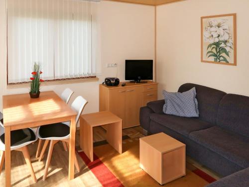 ein Wohnzimmer mit einem Sofa und einem Tisch in der Unterkunft Holiday Home Erzeberg-1 by Interhome in Balhorn