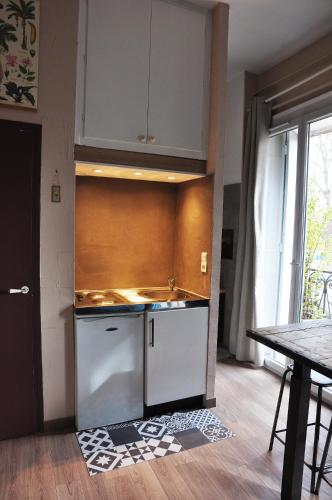 - une cuisine avec des placards blancs, un évier et une table dans l'établissement ✿ L'Escapade Occitane ✿(Occitan Getaway) - Arceaux, à Montpellier