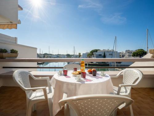 a table and chairs on a balcony with a view at Apartment Les Marinas d'Ulysse IV by Interhome in Le Grau-du-Roi