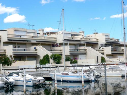 un groupe de bateaux amarrés devant un bâtiment dans l'établissement Apartment Les Marinas d'Ulysse IV by Interhome, au Grau-du-Roi