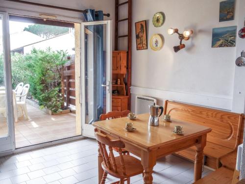 a dining room with a wooden table and a sliding glass door at Holiday Home Les Marines des Capellans by Interhome in Saint-Cyprien-Plage