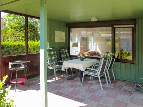 een patio met een tafel en stoelen op een huis bij Holiday Home Am Walde-1 by Interhome in Dobbertin