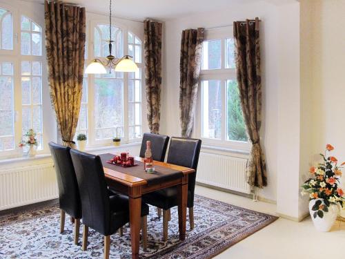 een eetkamer met een tafel, stoelen en ramen bij Apartment Wildrose by Interhome in Zempin