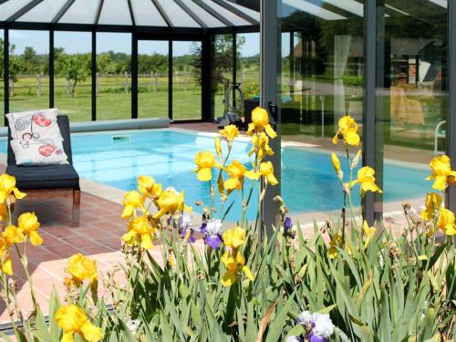 un jardín con flores amarillas junto a una piscina en Holiday Home La Prairie - CRB400 by Interhome, en Corbon