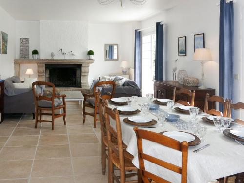 une salle à manger avec une table et des chaises et une cheminée dans l'établissement Holiday Home Pen Er Guer by Interhome, à Saint-Gildas-de-Rhuys