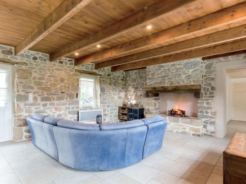 - un salon avec un grand canapé en face d'une cheminée en pierre dans l'établissement Holiday Home Le Vieux Chêne by Interhome, à Camaret-sur-Mer