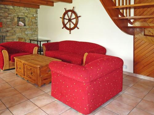 Telgruc-sur-MerにあるHoliday Home Trez Bellec - TGM101 by Interhomeのリビングルーム(赤いソファ、テーブル付)